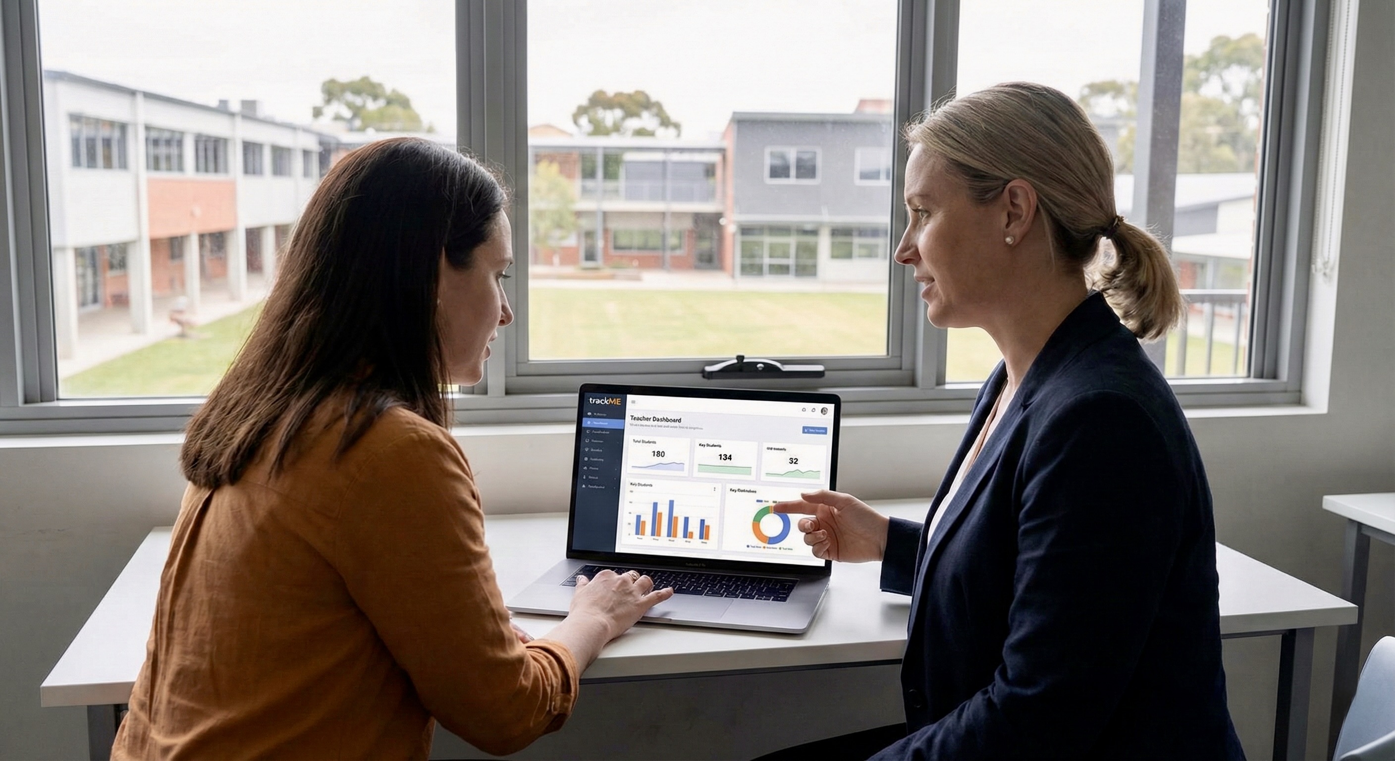 Two teachers discussing student progress in a staffroom